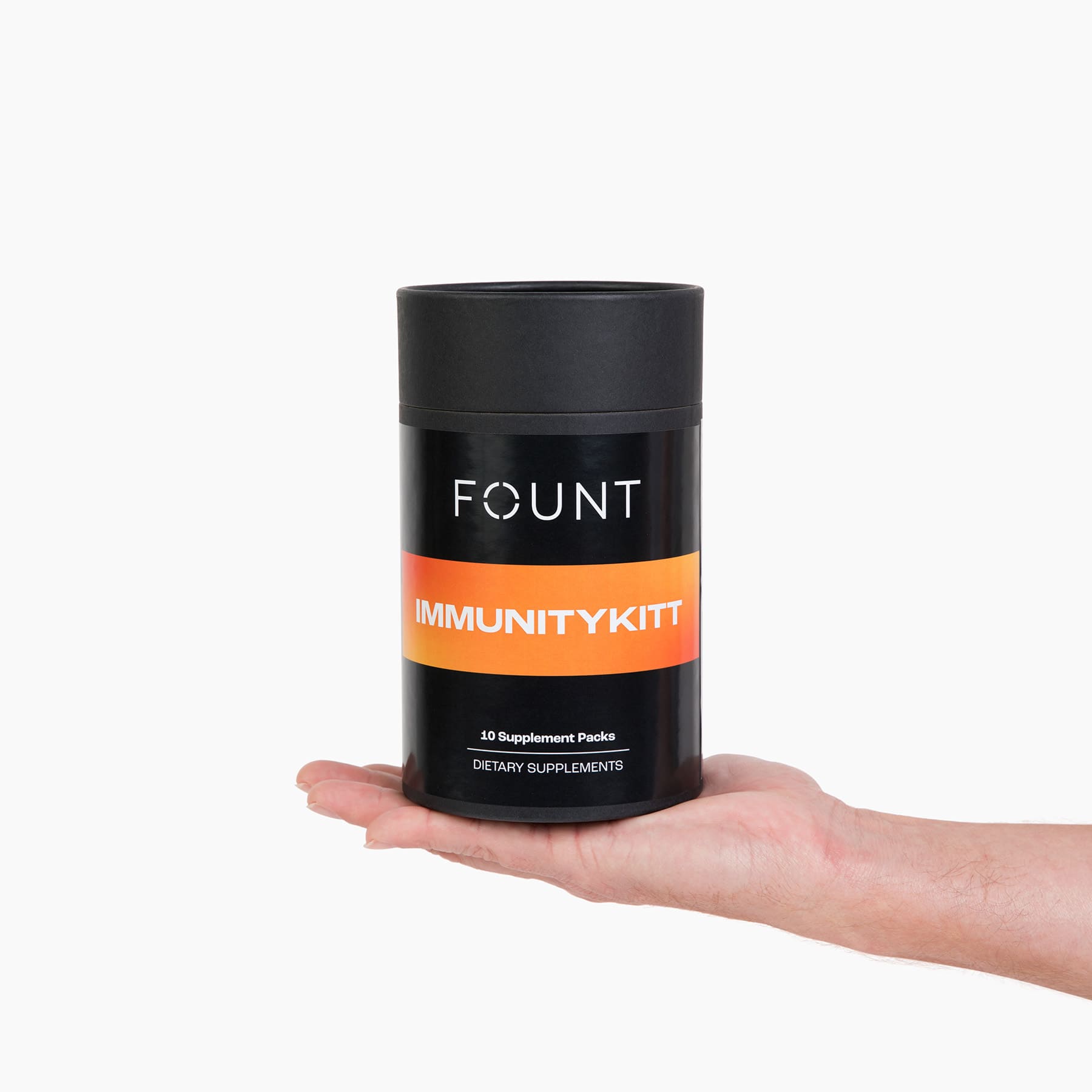 A hand holds a black cylindrical container labeled IMMUNITYKITT by KITTS in white and orange text, designed to support the immune system and enhance mental clarity. Inside are 10 supplement packs, all set against a pristine white background highlighting its sleek design.